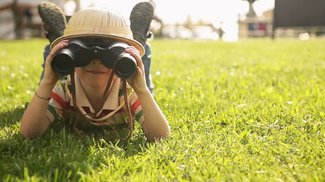 Child wearing pith helmet is playing at town park