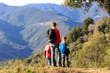 father with two kids travel in mountains