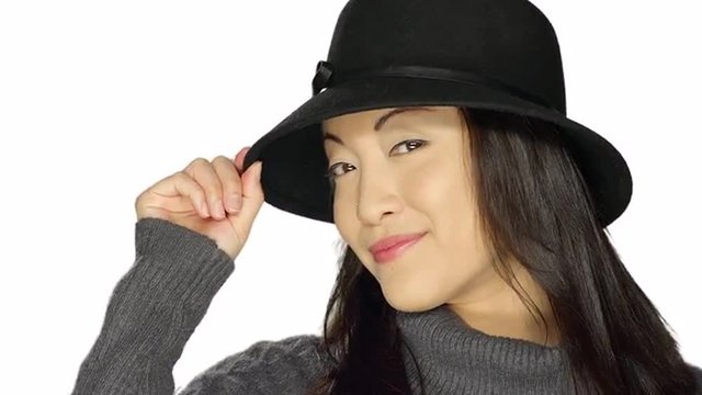Beautiful ethnic woman smiling and wearing a hat, on a white studio background