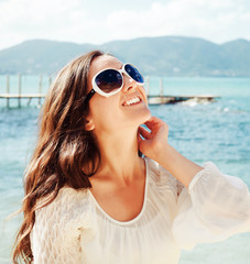 Happy woman in summer white dress on beach.