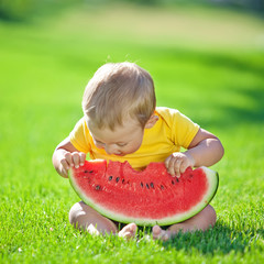 A boy are eating watermelon in nature 