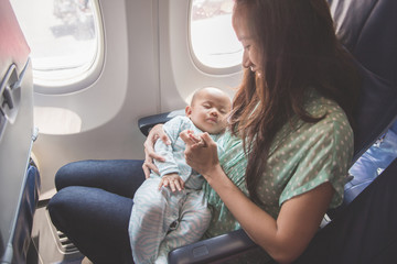 mother and baby sitting together in airplane