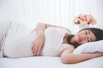 Obraz na płótnie Canvas Beautiful pregnant asian woman sleeping peacefully