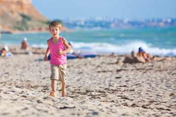 Happy boy are running on the beach 