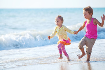 Happy kids are running on the beach 