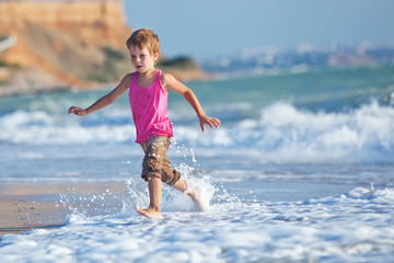 Happy boy are running on the beach 