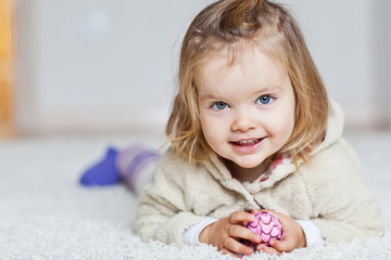 Happy little girl are liying in a carpet 