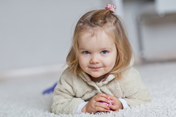 Fototapeta premium Happy little girl are liying in a carpet 