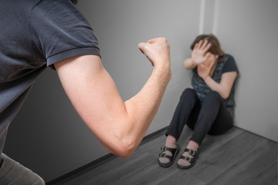 Domestic violence concept. Jealous husband is abusing his wife with fist.