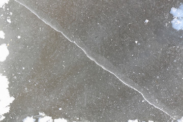 Crack on an ice surface of the frozen river, a natural backgroun