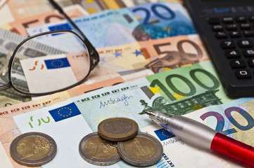 Eurogeldscheine, Brille und Taschenrechner