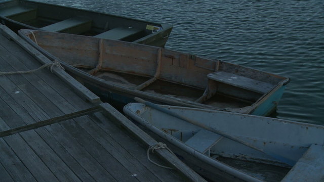 Three rowboats tied off to a dock in Rockport Harbor.