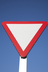 Blank Give Way Sign against Blue Sky Background