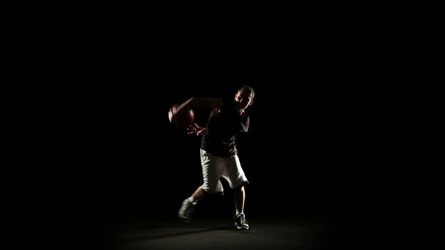 Young athletic sportsman perform basketball freestyle trick   