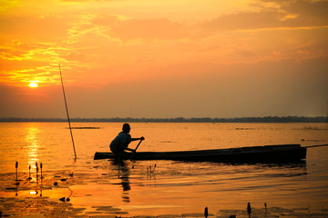 man in a boat on sunset sky 