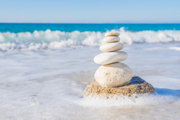 Stones pyramid on sand symbolizing zen, harmony, balance. Ocean
