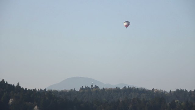 Aerostatic balloon flying over the hills