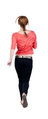 Fototapeta premium back view of running woman in jeans
