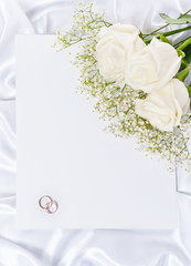 Obraz na płótnie Canvas Wedding rings with a roses and invitation