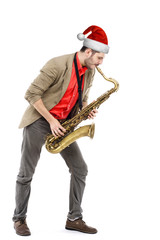 Fototapeta na wymiar man saxophonist in Santa hat playing saxophone player in studio
