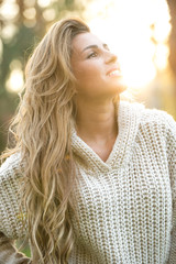 Beautiful girl posing in winter sweater on a sunny day