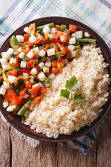 Couscous with vegetables and herbs closeup. vertical top view
