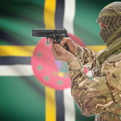 Male with gun in hands and national flag on background - Dominica