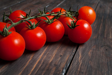 Fototapeta na wymiar Fresh cherry tomatoes on wood background