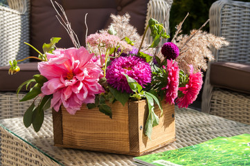 a bouquet of different flowers in a wooden box on the table