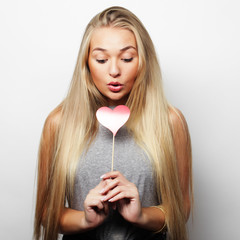  Playful young woman holding a party heart.