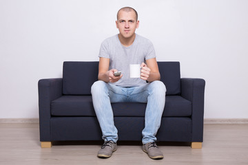 handsome man watching tv with cup of tea