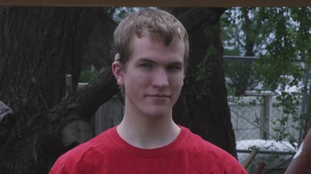 Static shot of a deaf young man wearing a hearing aid