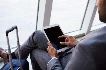 Businessman Using Digital Tablet In Airport Departure Lounge