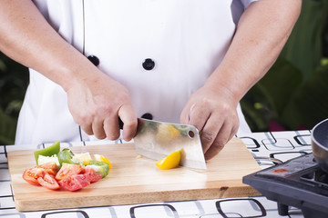 Obraz na płótnie Canvas Chef cutting yellow bell pepper