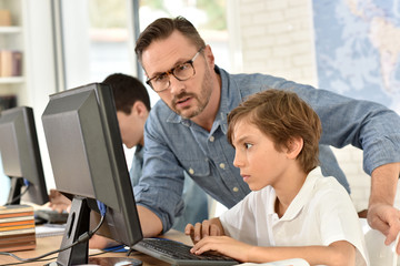 Obraz premium Teacher with kids in computing class