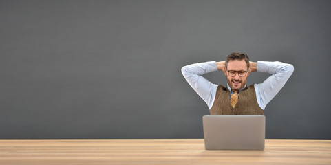 Businessman relaxing in front of laptop, isolated