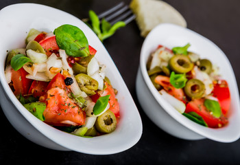 Fresh salad with tomatoes, lamb's lettuce, olives and onion