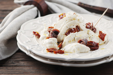 Traditional italian antipasto with burrata and dry tomato