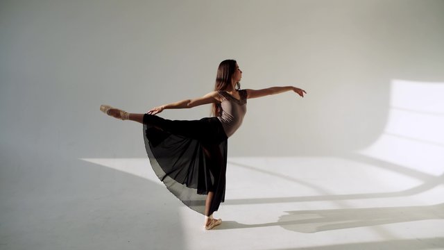 silhouette of ballerina in classical tutu in the white studio.