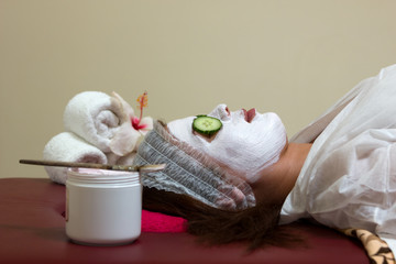Woman with clay facial mask in beauty spa