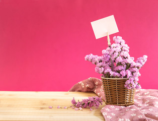 sweet statice flower in basket with blank paper label 