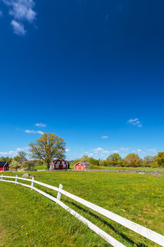Old Swedish red wooden farm buildings with white fence