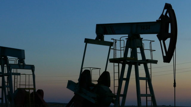 working oil pumps silhouette in dusk, zoom in
