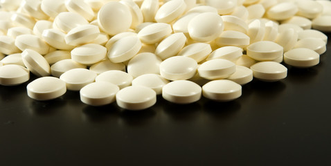 Fototapeta na wymiar white pills on a black background