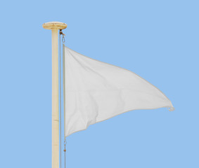 White pennant flying in a brisk breeze against a pale blue sky