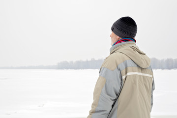 Fototapeta na wymiar Man Close to the Frozen River in Winter