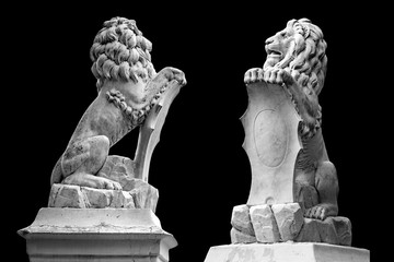 Marble statue of lion holding a shield in its paws. Regal lion leaning on empty heraldic shield...