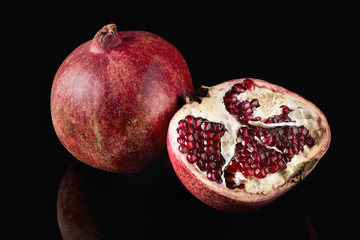 Ripe pomegranate on black background