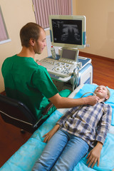 girl getting ultrasound of a thyroid from doctor