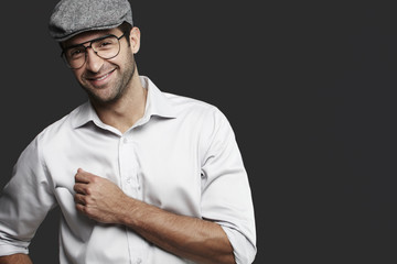Young man in cap and glasses in studio